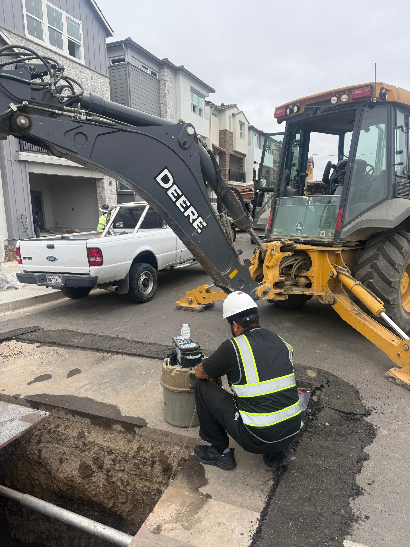 Technician collecting a wastewater sample from a street manhole.