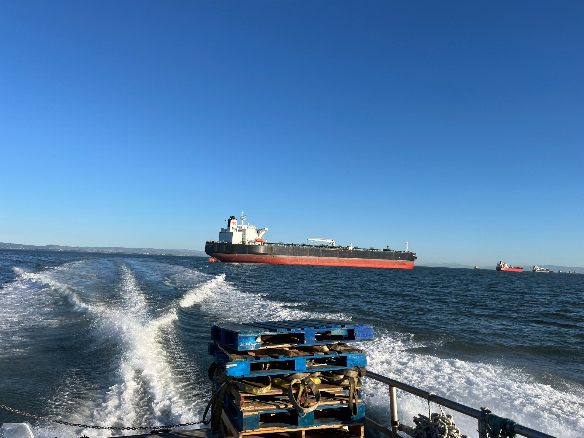 Tanker vessel viewed from a sampling boat approaching in open water.